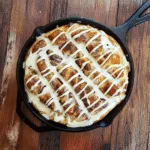 Cinnamon roll focaccia with glaze in cast iron pan