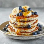 blender banana cottage cheese pancakes stack with syrup and fruit