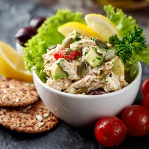 Easy rotisserie chicken salad served in bowl with avocado, tomatoes, and herbs.